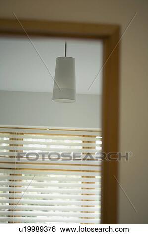 Stock Photograph - Reflection of window and pendant light in mirror. Fotosearch