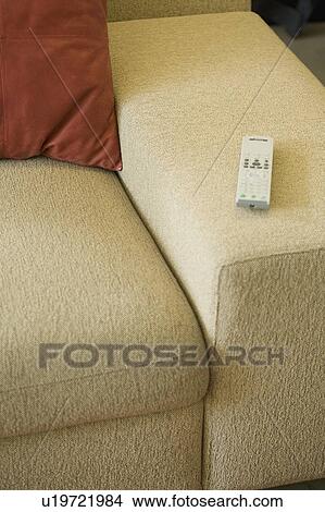 Picture - Remote on arm of sofa. Fotosearch