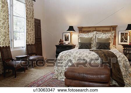 Stock Photo - Sitting area and bed in traditional bedroom. Fotosearch