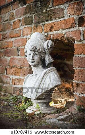 Stone statue of a girl near a brick wall View Large Photo Image Stock Photography - Stone statue of a girl near a brick wall. Fotosearch