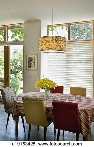 Stock Photography - Vase of yellow flowers on red and gold kitchen table. Fotosearch