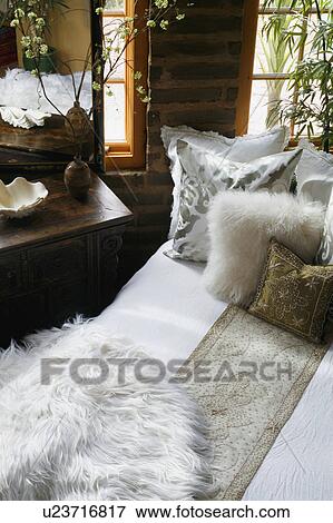 Stock Photo - White and gold bed runner and pillows on bed. Fotosearch