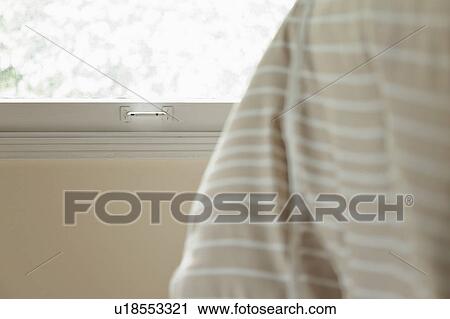 Stock Image - Window detail behind comforter on bed. Fotosearch
