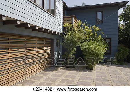 Stock Photo - Wooden garage door and blue sided home. Fotosearch