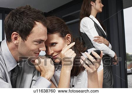 Stock Image - Attractive business woman speaking to a business man. Fotosearch