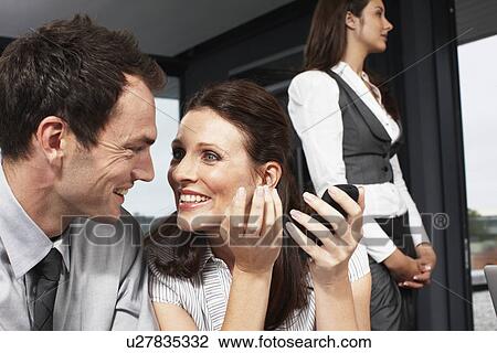 Stock Image - Beautiful business woman speaking to a colleague. Fotosearch