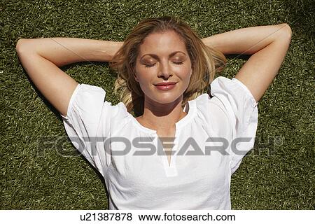 Stock Photo - Beautiful girl on the grass. Fotosearch