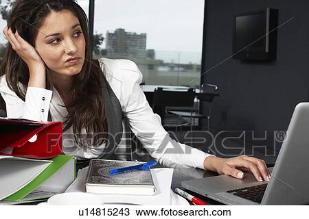 Stock Image - Bored girl at work. Fotosearch
