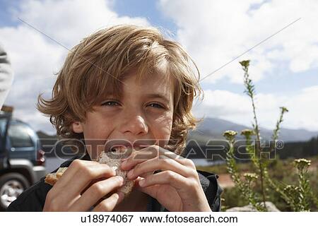 Boy eating a sandwich View Large Photo Image Stock Photo - Boy eating a sandwich. Fotosearch