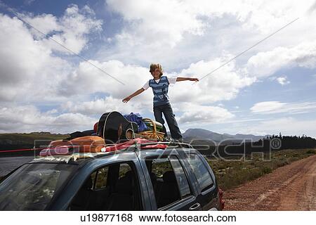 Stock Photo - Boy playing on the roof of a car. Fotosearch