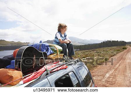 Boy sitting on the roof of a car View Large Photo Image Stock Image - Boy sitting on the roof of a car. Fotosearch