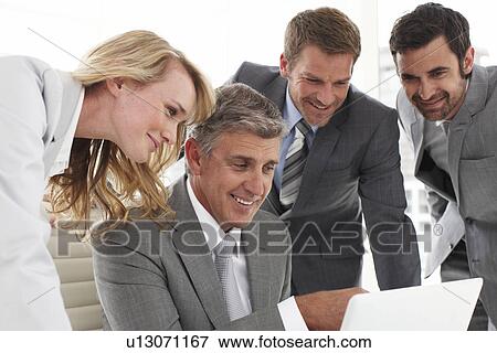 Stock Photo - Business people looking at a computer screen. Fotosearch