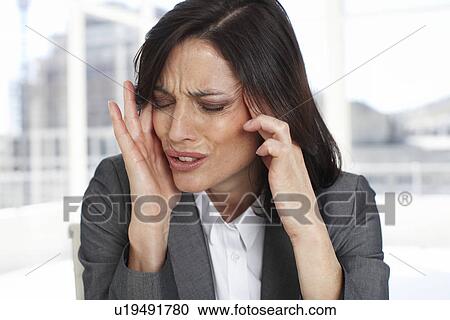 Stock Image - Business woman having headache. Fotosearch