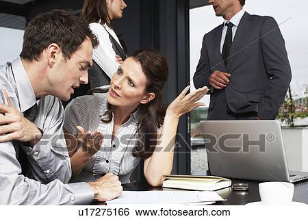 Stock Photograph - Business woman speaking to a younger man. Fotosearch