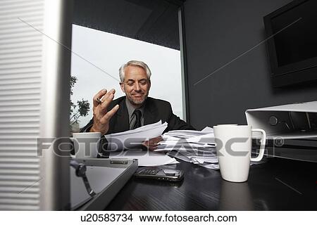 Picture - Businessman doing paper work. Fotosearch