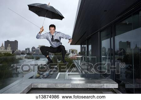 Stock Photograph - Businessman jumping in rain. Fotosearch