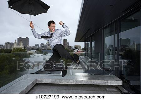 Businessman jumping in the rain View Large Photo Image Stock Photo - Businessman jumping in the rain. Fotosearch