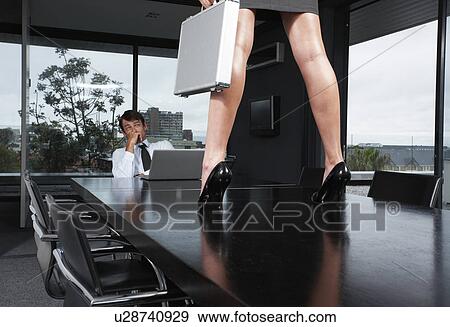 Stock Photo - Businessman looking at woman's legs. Fotosearch