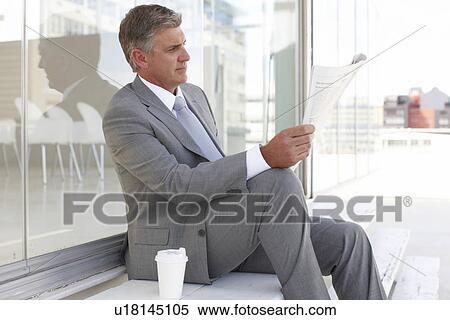 Businessman reading a newspaper View Large Photo Image Stock Photography - Businessman reading a newspaper. Fotosearch