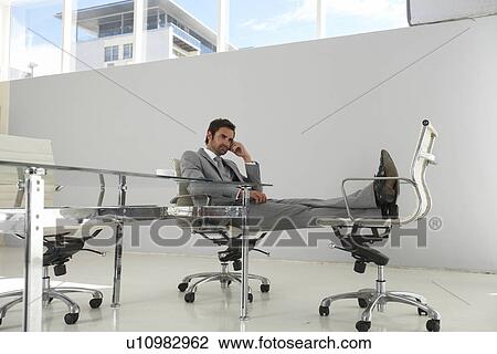 Businessman with legs on a chair View Large Photo Image Stock Image - Businessman with legs on a chair. Fotosearch