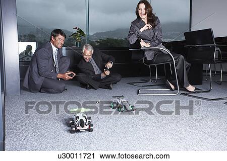 Stock Image - Businessmen playing with toys. Fotosearch