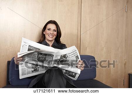 Stock Image - Businesswoman reading newspaper. Fotosearch