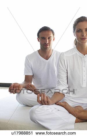 Stock Image - Couple doing yoga. Fotosearch