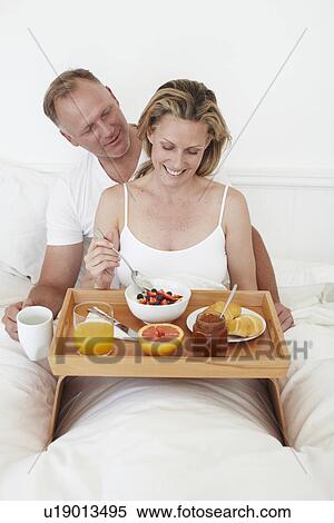 Stock Photography - Couple having breakfast in bed. Fotosearch