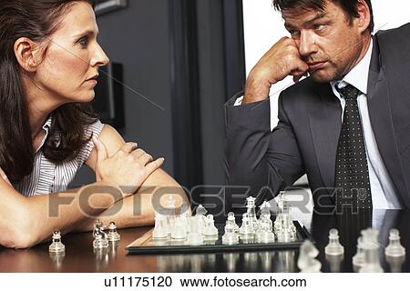 Stock Image - Couple playing chess. Fotosearch