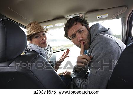 Stock Photography - Couple silencing kids in a car. Fotosearch