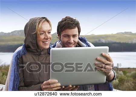 Stock Image - Couple with a laptop. Fotosearch