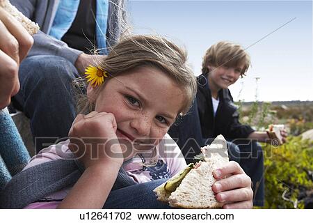 Stock Image - Cute girl eating a sandwich. Fotosearch