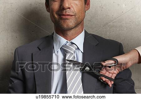 Stock Image - Cutting a tie. Fotosearch