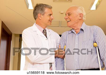 Stock Photo - Doctor assisting a disabled senior. Fotosearch