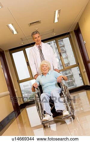 Doctor assisting a patient View Large Photo Image Picture - Doctor assisting a patient. Fotosearch
