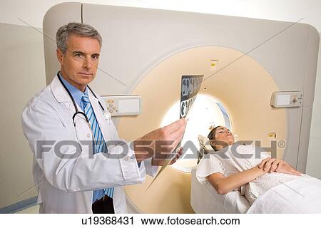 Stock Image - Doctor examining a scan. Fotosearch