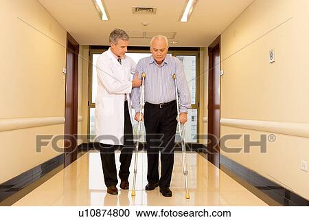 Stock Image - Doctor helping a disabled. Fotosearch