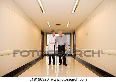 Stock Image - Doctor helping a senior man. Fotosearch