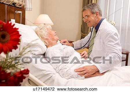 Stock Image - Doctor looking after a senior patient. Fotosearch