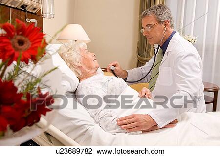 Stock Image - Doctor visiting senior patient. Fotosearch