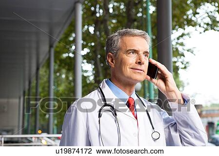 Doctor with a mobile phone View Large Photo Image Stock Image - Doctor with a mobile phone. Fotosearch
