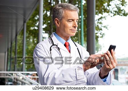 Stock Photo - Doctor with a mobile phone. Fotosearch