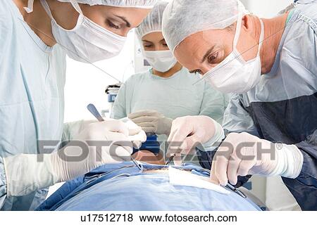 Stock Photo - Doctors performing a surgery. Fotosearch