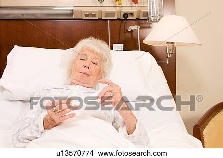 Picture - Elderly taking pills. Fotosearch