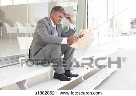Stock Image - Executive reading a newspaper. Fotosearch