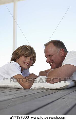 Stock Image - Father and son in a beach house. Fotosearch