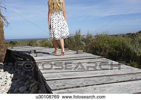 Stock Photo - Girl walking in the fields. Fotosearch