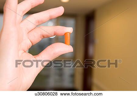 Hand holding a pill View Large Photo Image Stock Photo - Hand holding a pill. Fotosearch