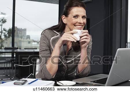 Stock Image - Happy business woman at work. Fotosearch