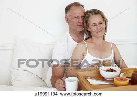 Picture - Happy couple having breakfast. Fotosearch